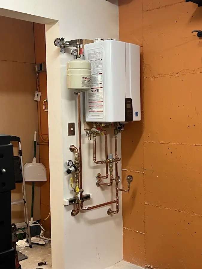 Plumbing technician inspecting water heater connections in Woodbury